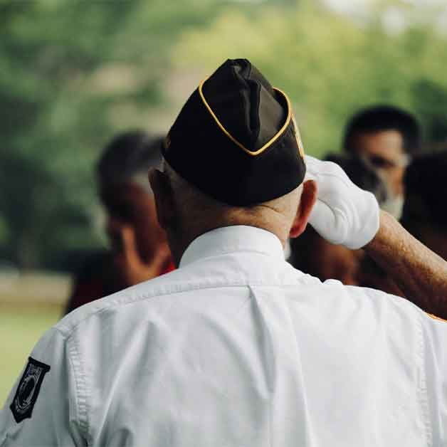 A rear angle of a veteran saluting