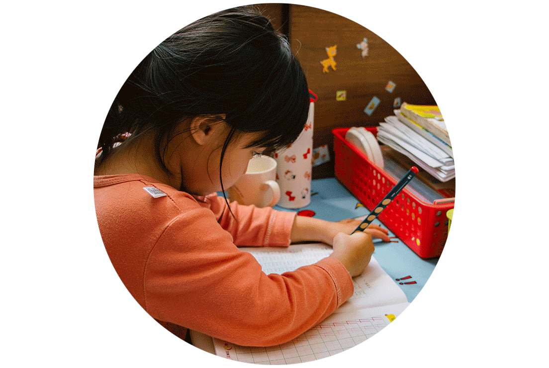 A kindergarten student learning to write